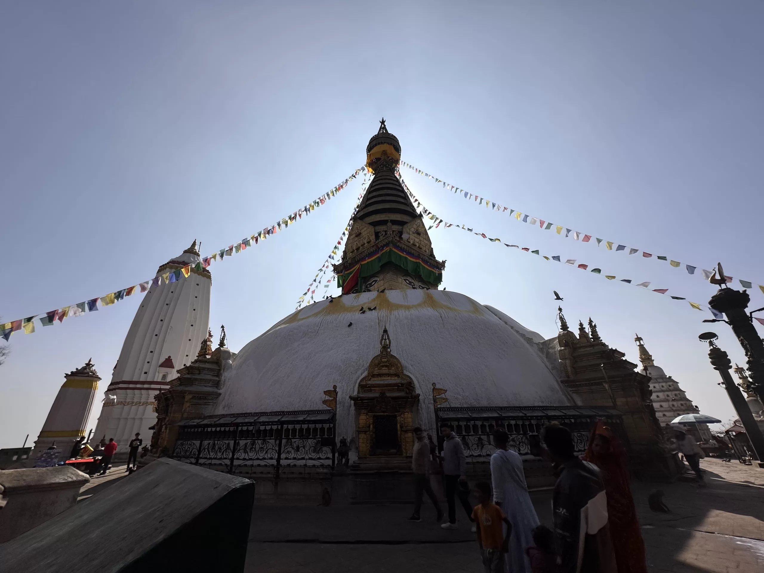 Estupa y ruedas de oración con banderas tibetanas en el templo de Katmandú
